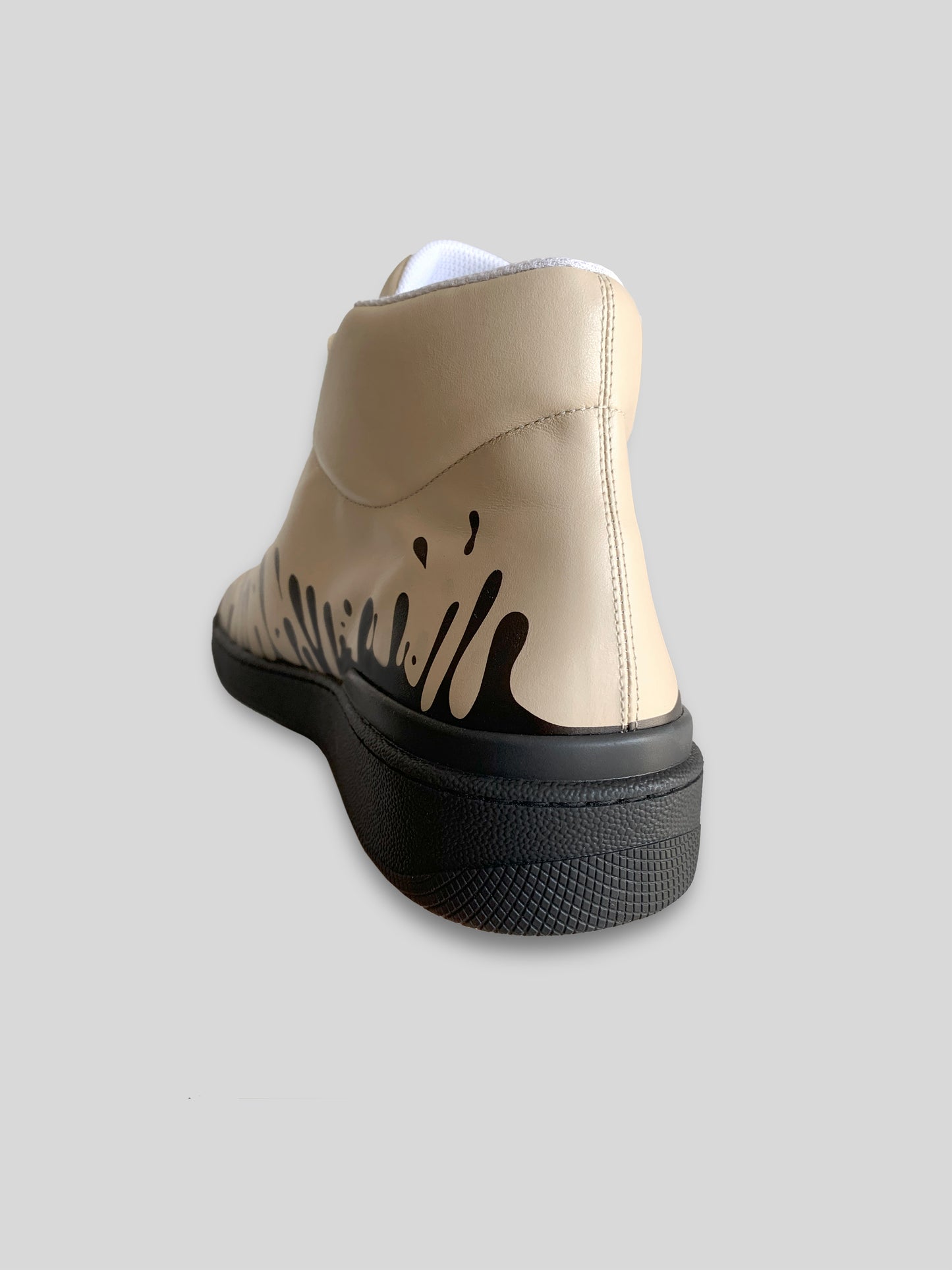 Back and inside exterior view of beige Nappa leather mid-top sneaker with exclusive printed black drops design and black sole