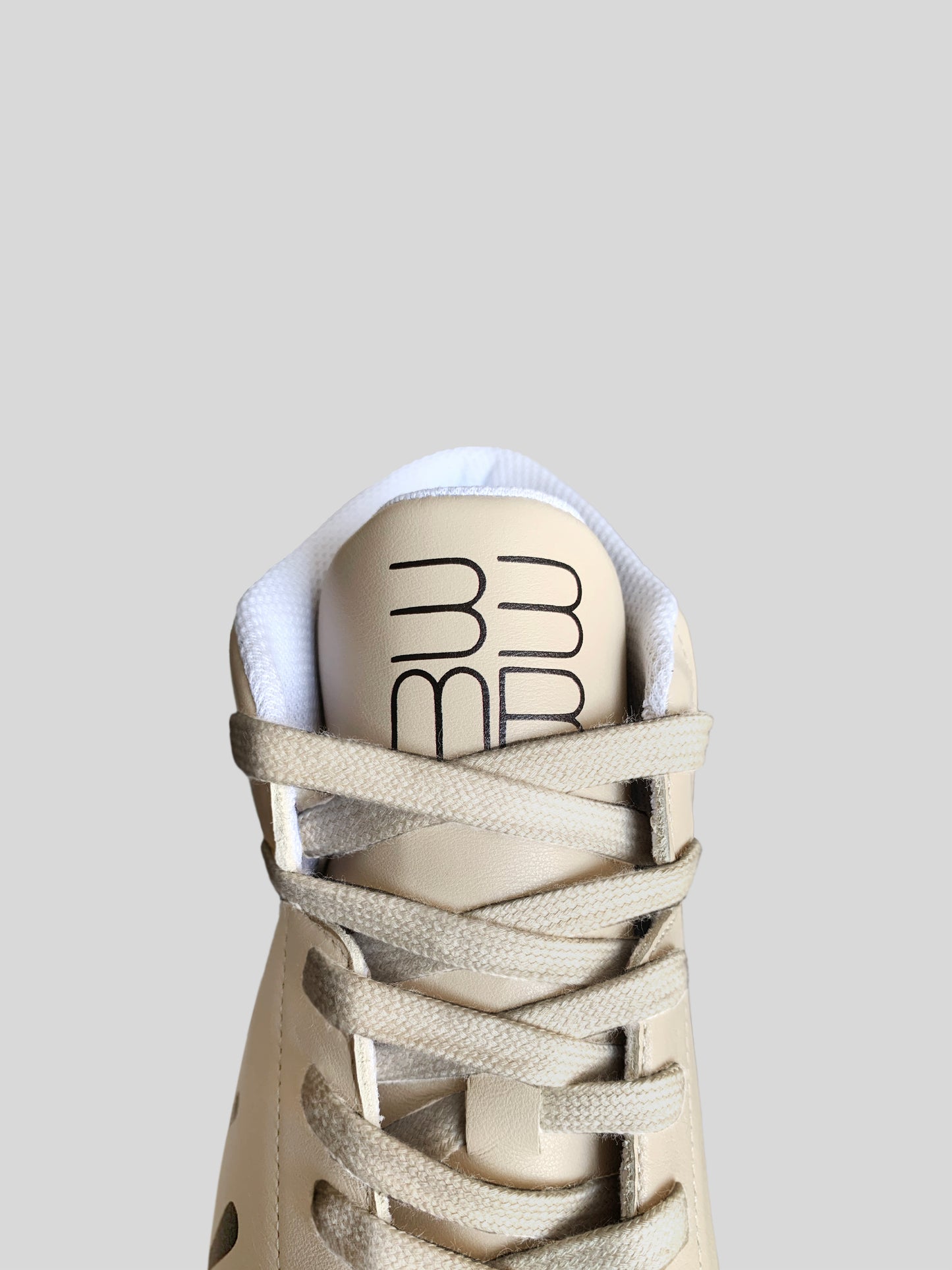 Front focus of beige Nappa leather mid-top sneaker with printed black drops design