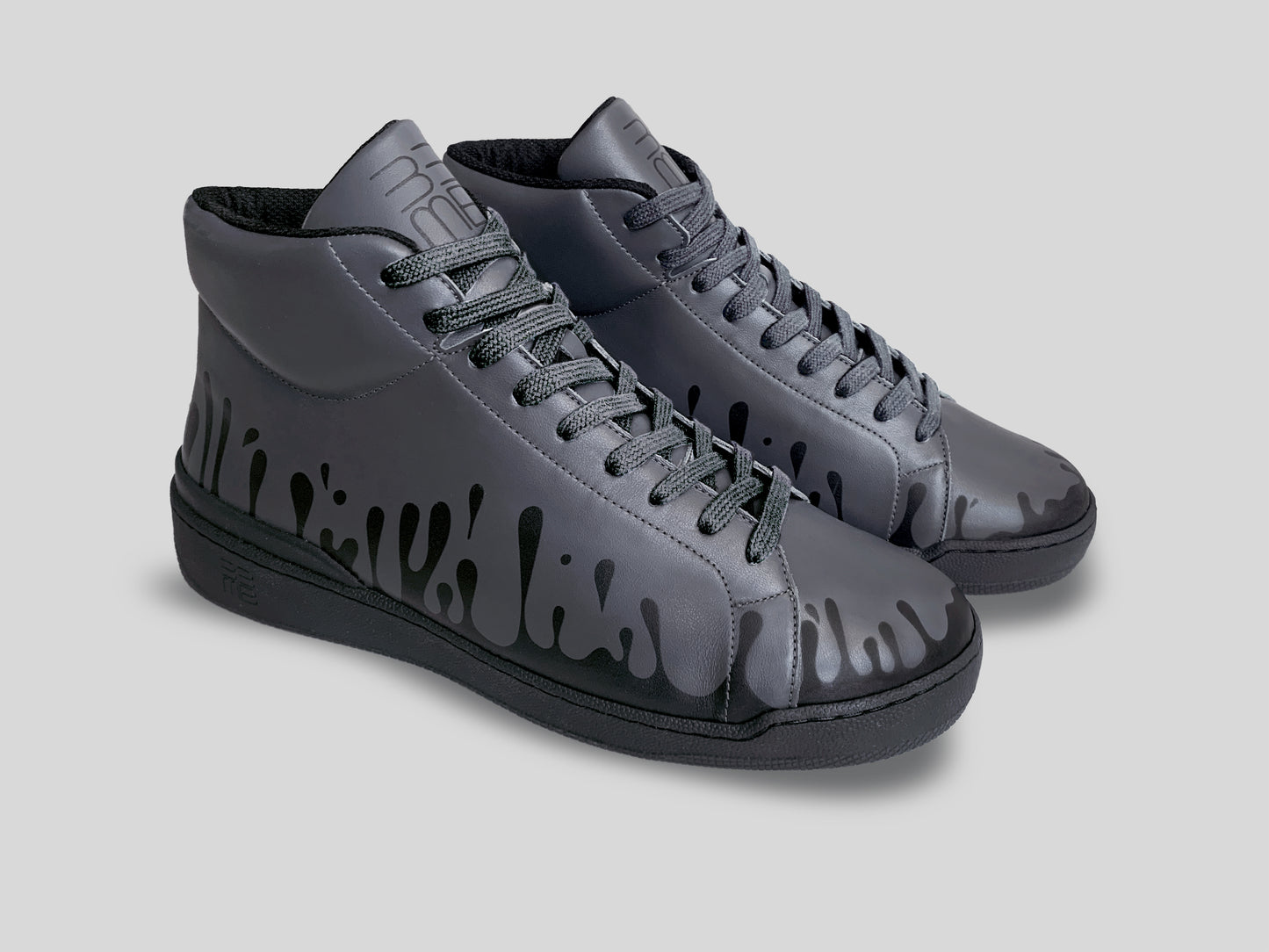 Side profile of pair of 33MB Nighty mid-top sneakers in dark grey leather, showcasing the black Zero Gravity paint drops traveling upward from the sole.