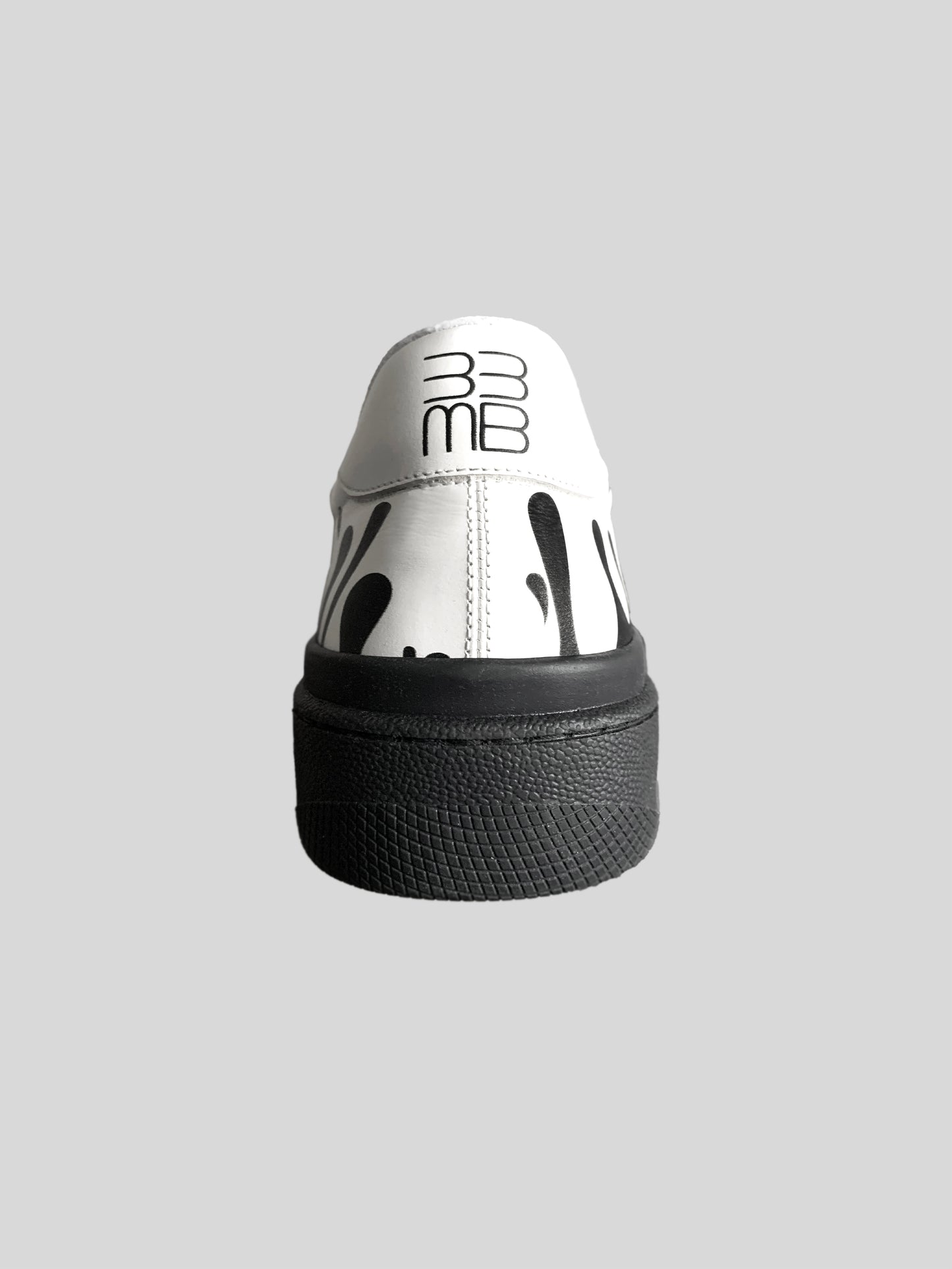 Back view of White Nappa leather low-top sneaker with exclusive black drops design on black sole
