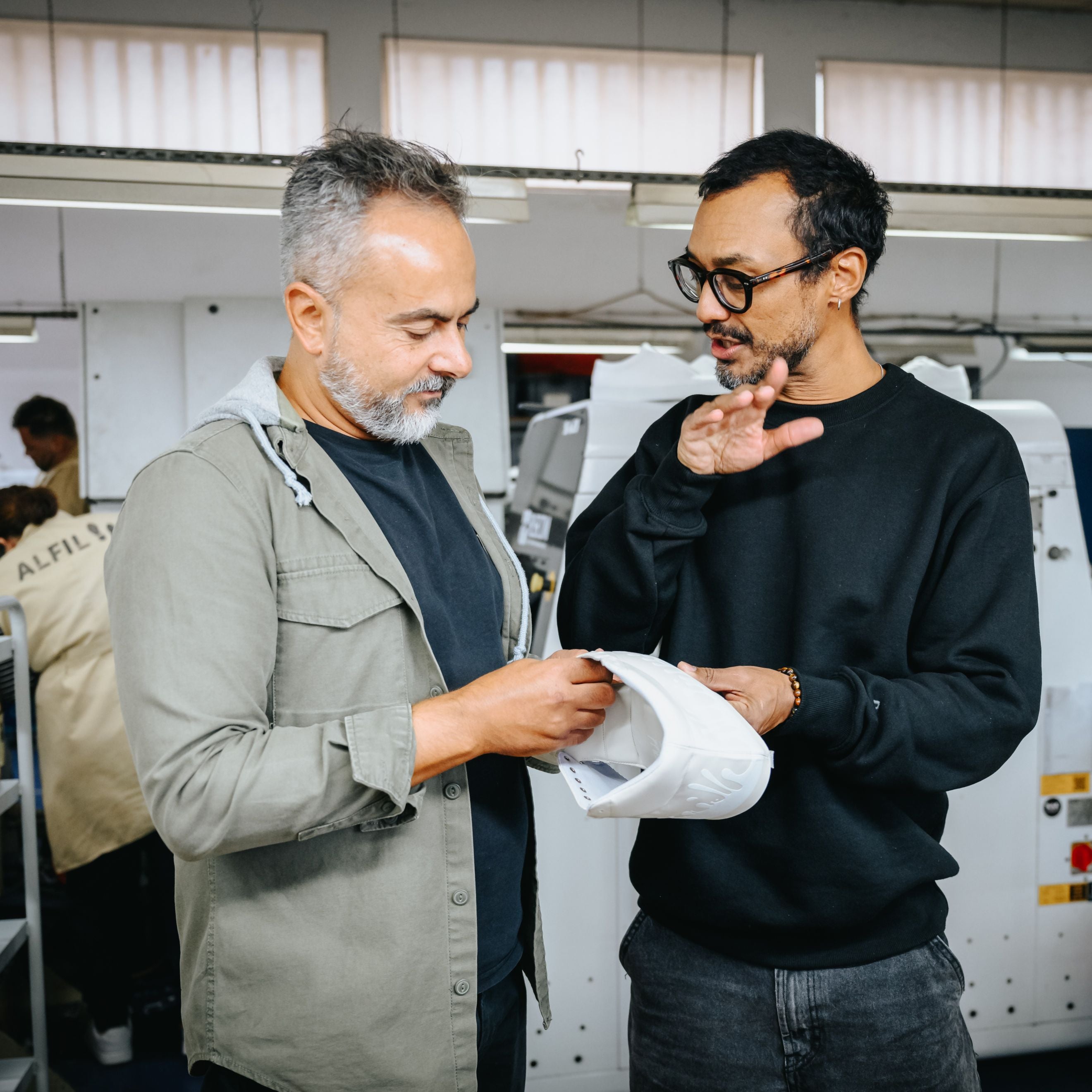 Miguel Berthelot talking to the head of the factory about the sneakers with leather in hand