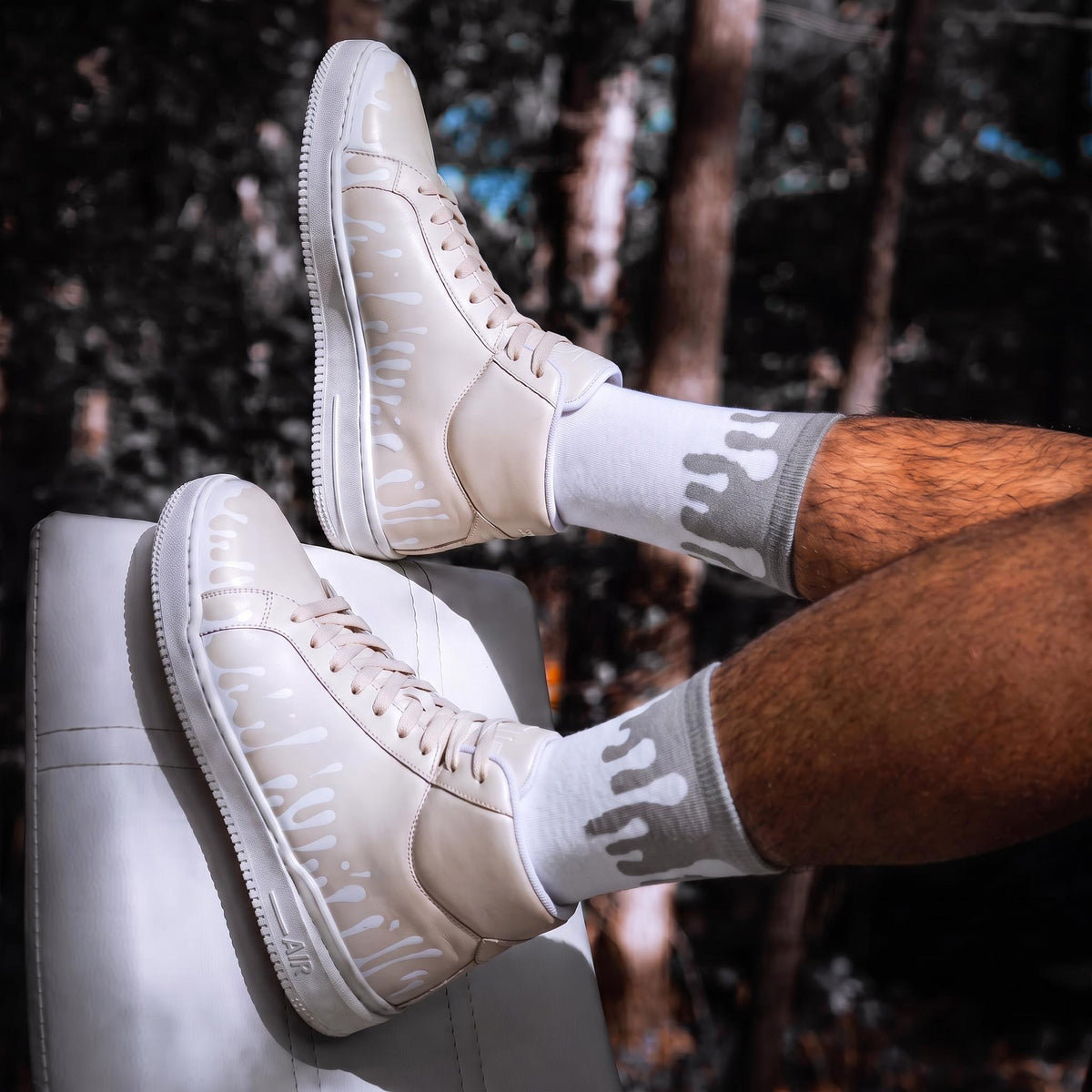 33MB Dawn cream mid-top leather sneakers with Zero Gravity® upward-drop motif paired with Lunar organic cotton socks with trees in the background.