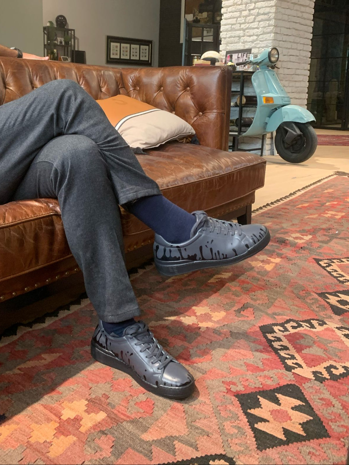 Dark grey Nappa leather low-top sneakers with exclusive printed black drops design and black soles worn with grey pants