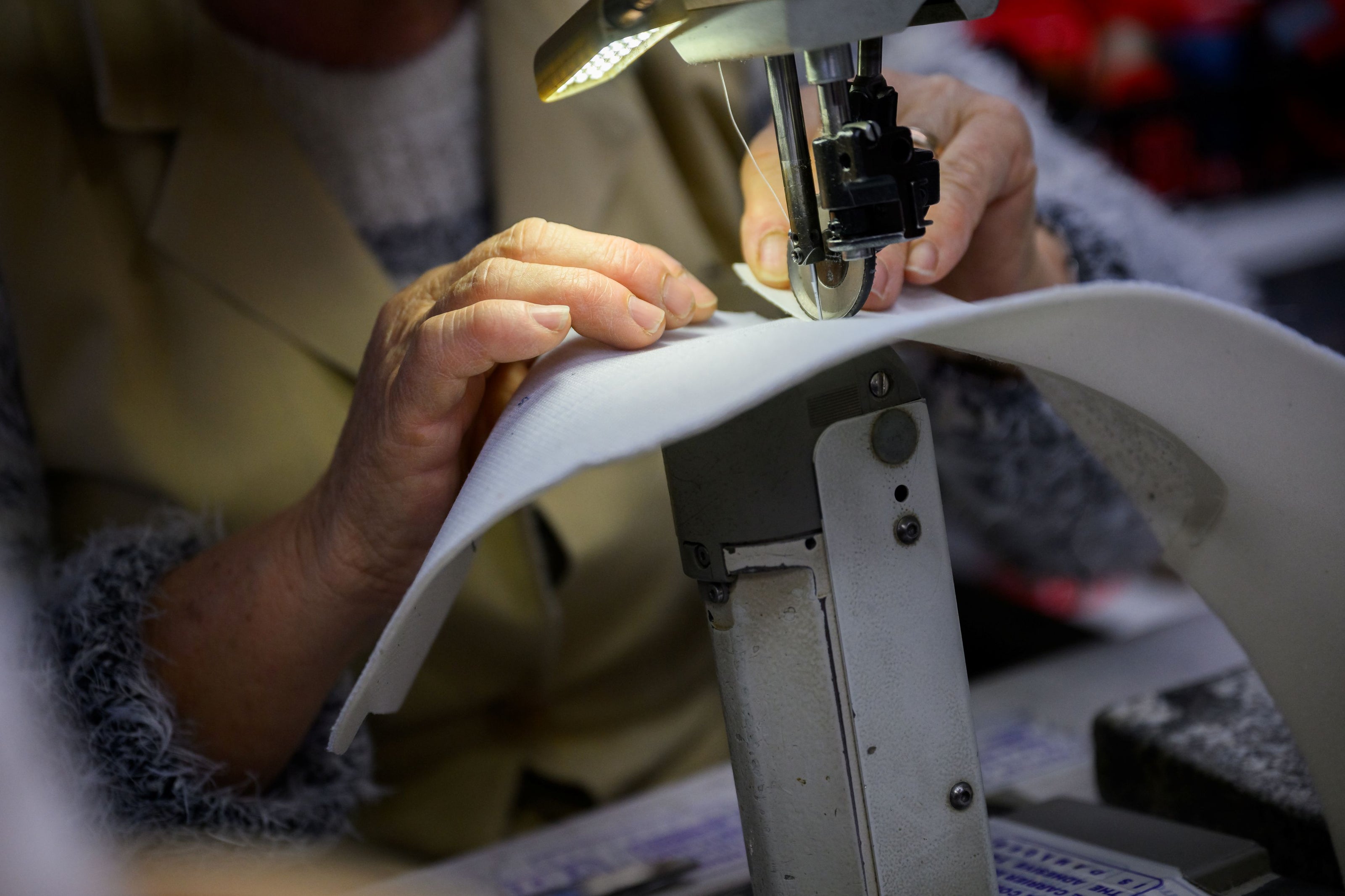 Hands of an Artisan sewing our 33MB premium leather sneaker