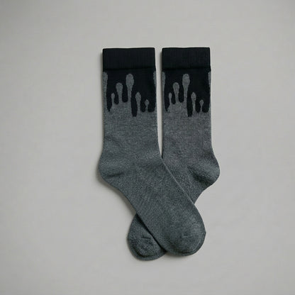 Pair of premium 33MB organic cotton crew socks in dark grey and black featuring the signature Zero Gravity design of paint droplets flowing upward, symbolizing hope and constant positivity