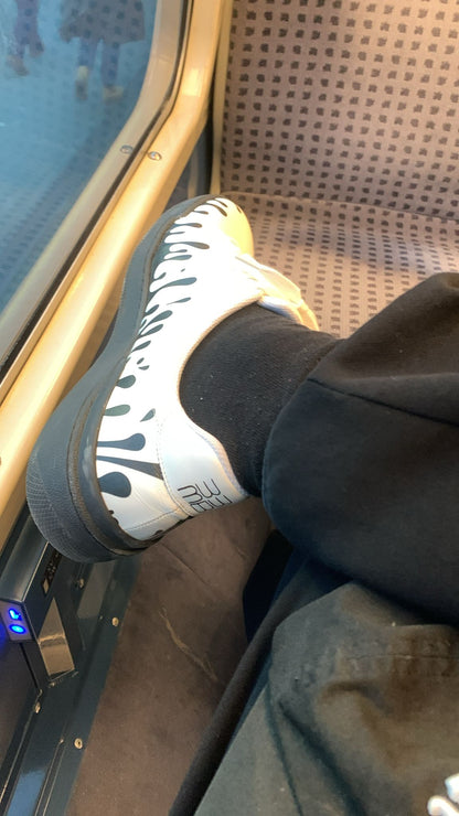 White Nappa leather low-top sneaker with exclusive printed black drops design and black sole worn with black jogger