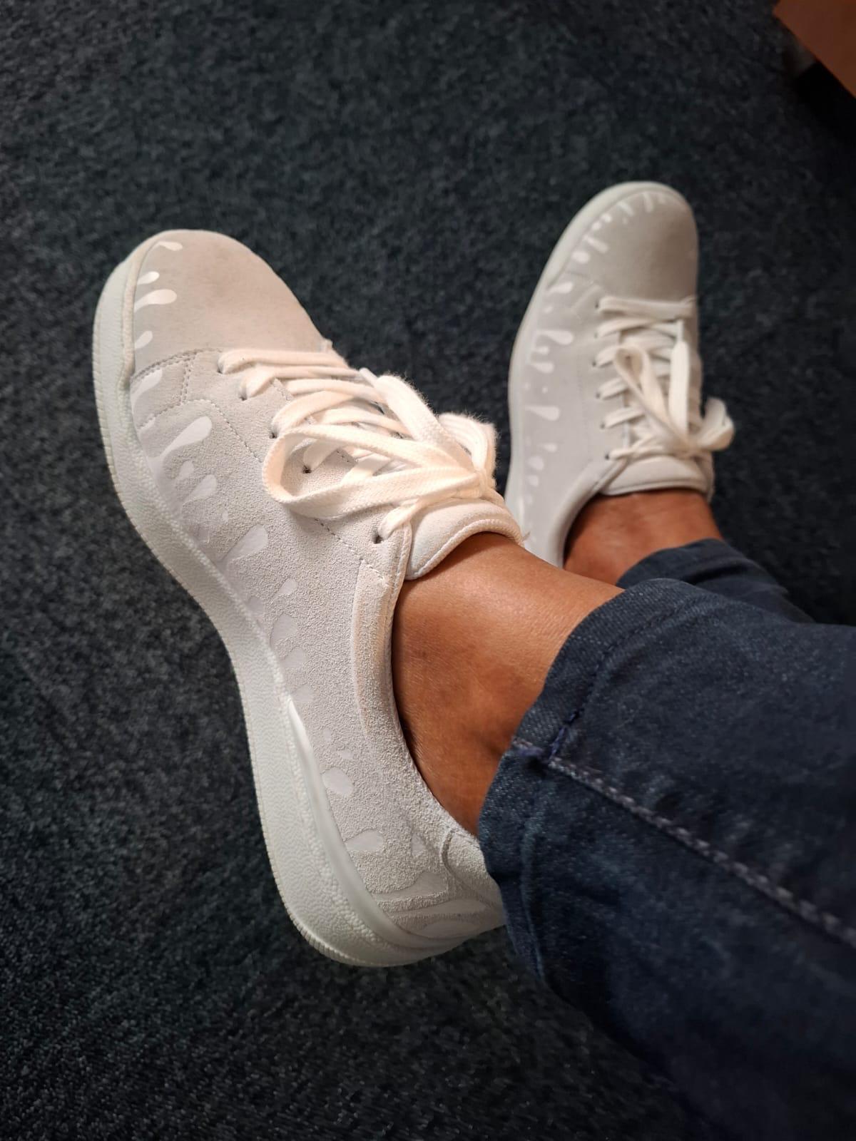33MB Nuage light grey suede sneakers featuring the Zero Gravity® upward-drop motif worn with dark jeans on a dark carpeted floor