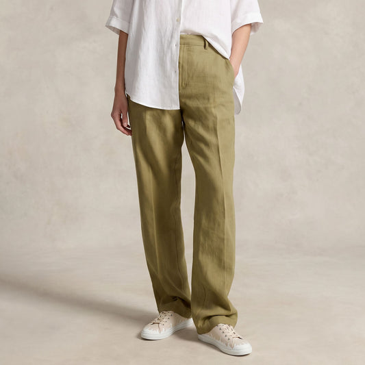 A person wearing olive green wide-leg linen trousers, styled with a white short-sleeve button-up shirt and 33MB low-top Mirage sandy recycled  canvas sneakers featuring the Zero Gravity® upward-drop motif representing hope  with white soles,  standing against a textured beige studio backdrop.