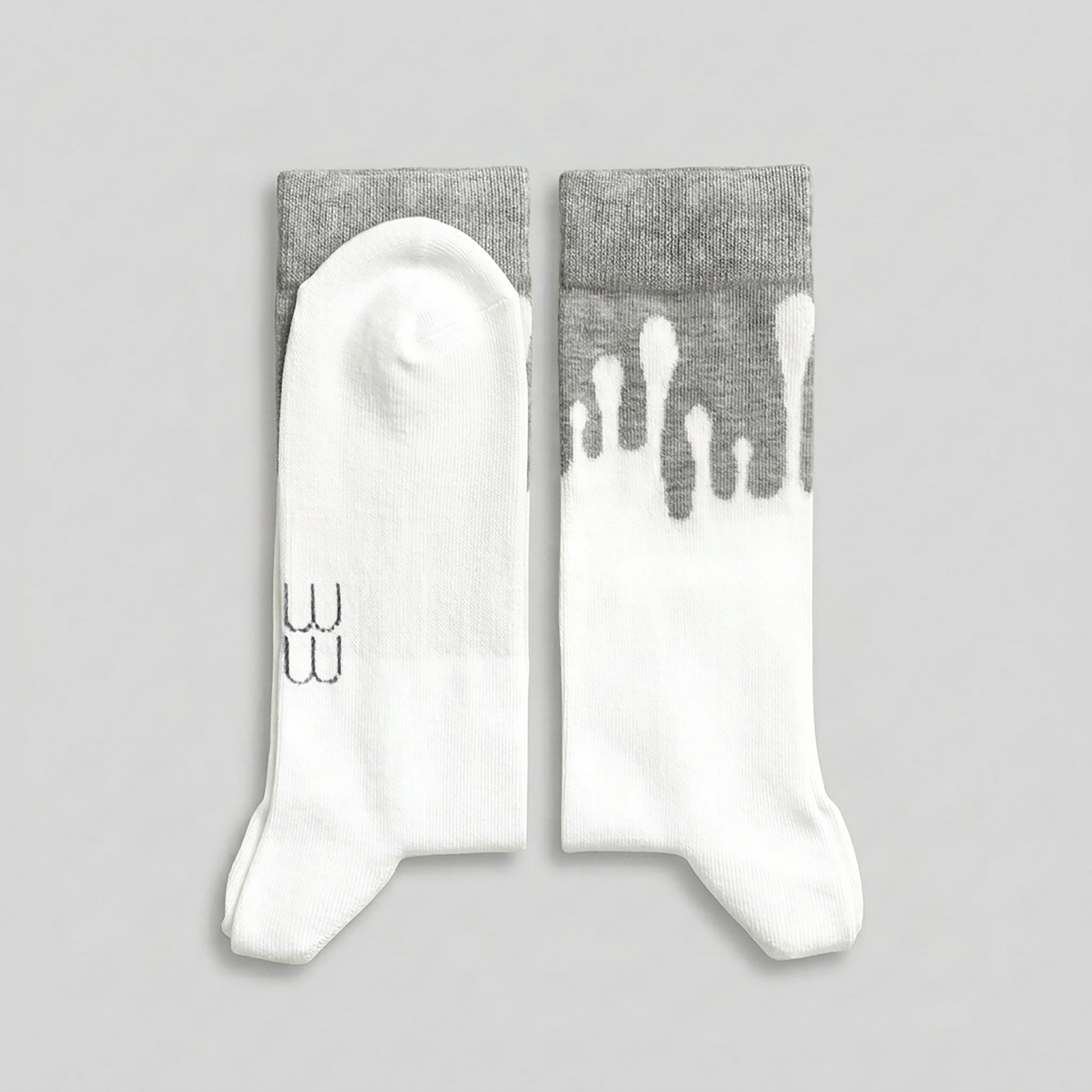Folded 33MB brand organic cotton crew socks. The "Zero Gravity" pattern showswhite paint splatters moving vertically toward the grey cuff, symbolizing upward momentum and positivity.