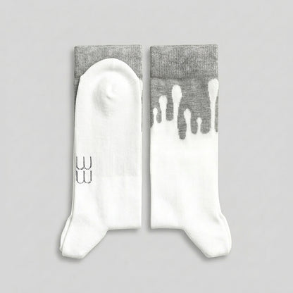 Folded 33MB brand organic cotton crew socks. The "Zero Gravity" pattern showswhite paint splatters moving vertically toward the grey cuff, symbolizing upward momentum and positivity.