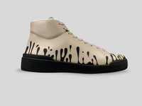 Side profile of 33MB Coco-Ah mid-top sneakers in beige Italian leather, showcasing the black Zero Gravity paint drops traveling upward from the sole.