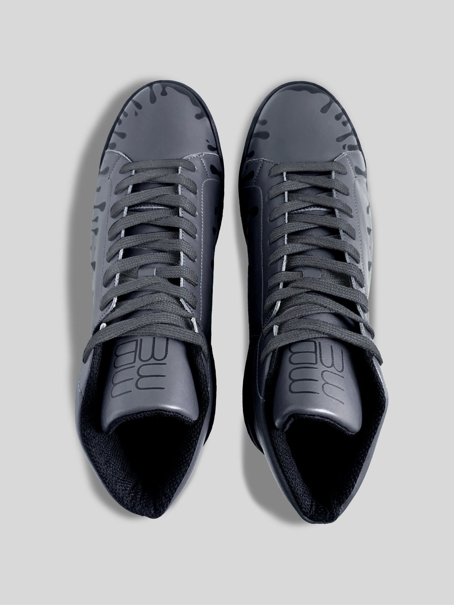 Top of view of pair of dark grey Chrome-free Nappa leather mid-top sneakers with exclusive printed black drops design