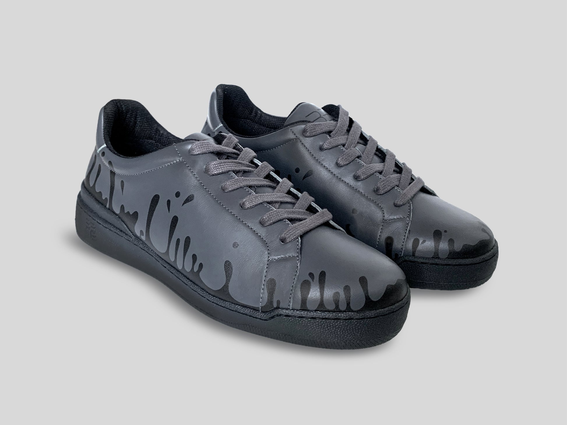 Pair of dark grey Chrome-free Nappa leather low-top sneakers with exclusive printed black drops design and black soles