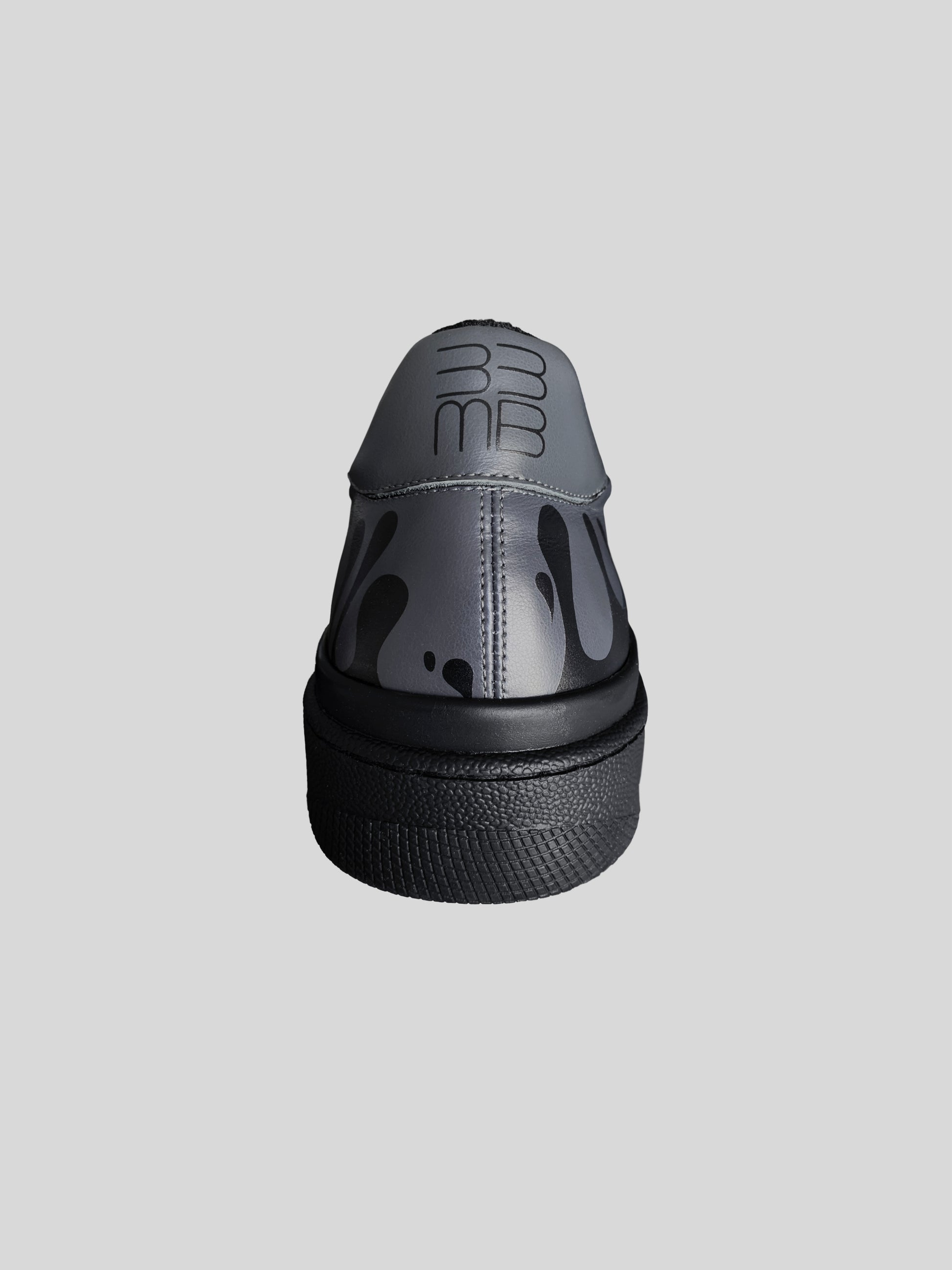 Back view of dark grey Chrome-free Nappa leather low-top sneaker with exclusive printed black drops design and black sole