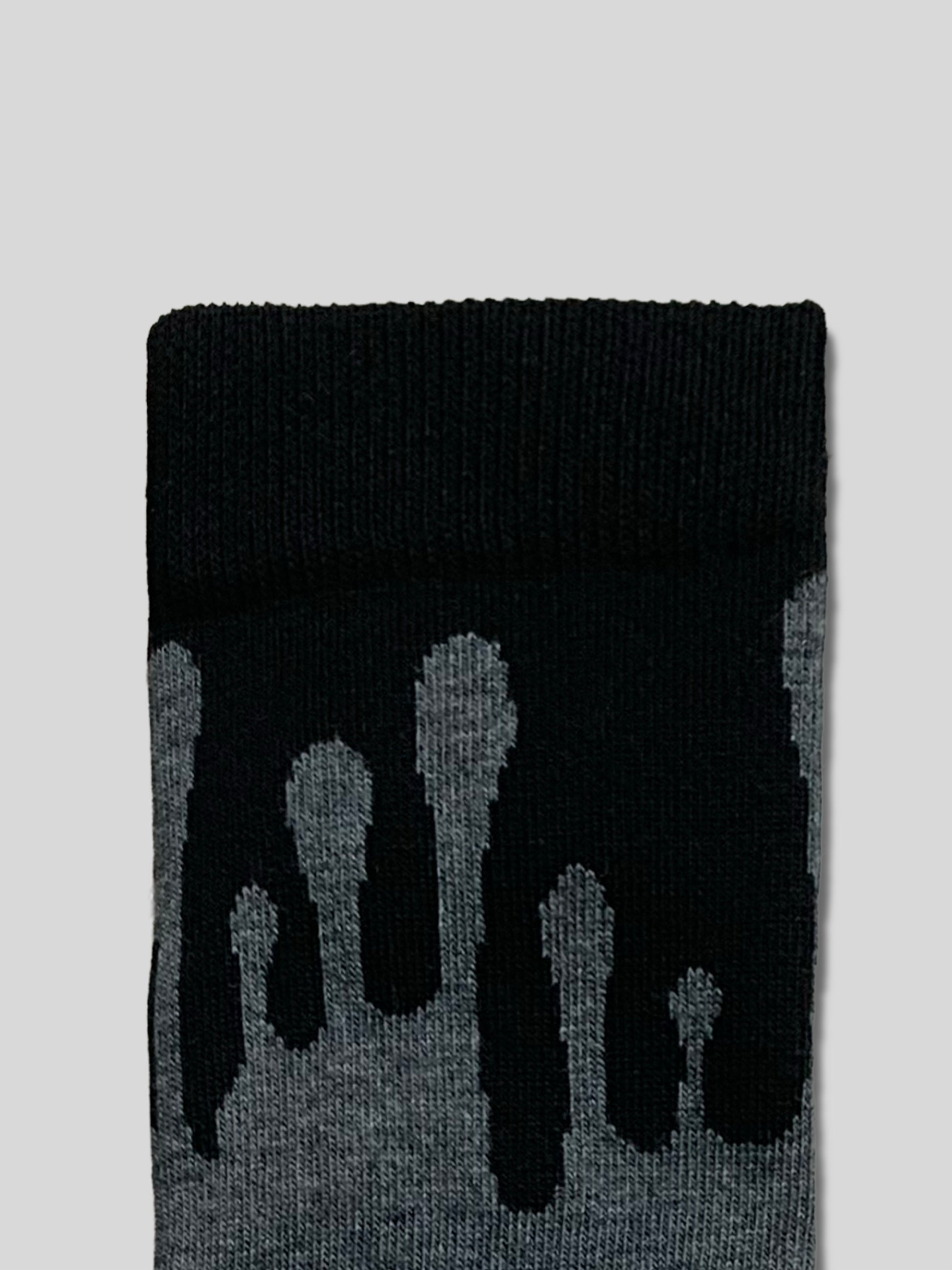 Detailed perspective of the 33MB Zero Gravity pattern. Intense grey paint drops flow upward on a backdrop of textured organic cotton. A white band with the 33MB logo is seen at the base of the design.
