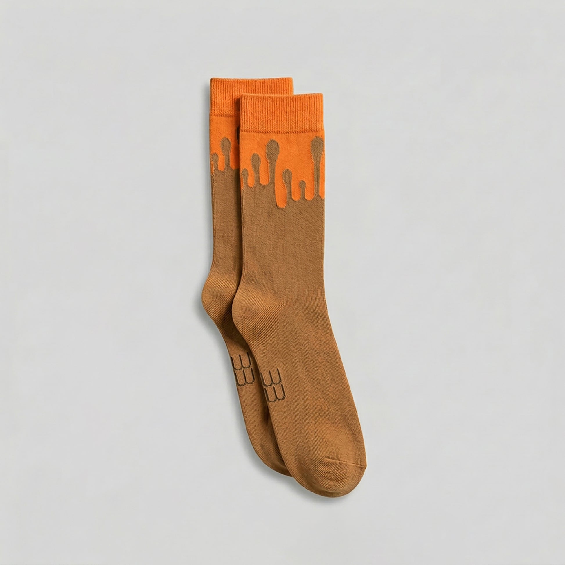 Pair of premium 33MB organic cotton crew socks in camel  and orange featuring the  Zero Gravity® signature motif of paint droplets flowing upward, symbolizing hope and constant positivity
