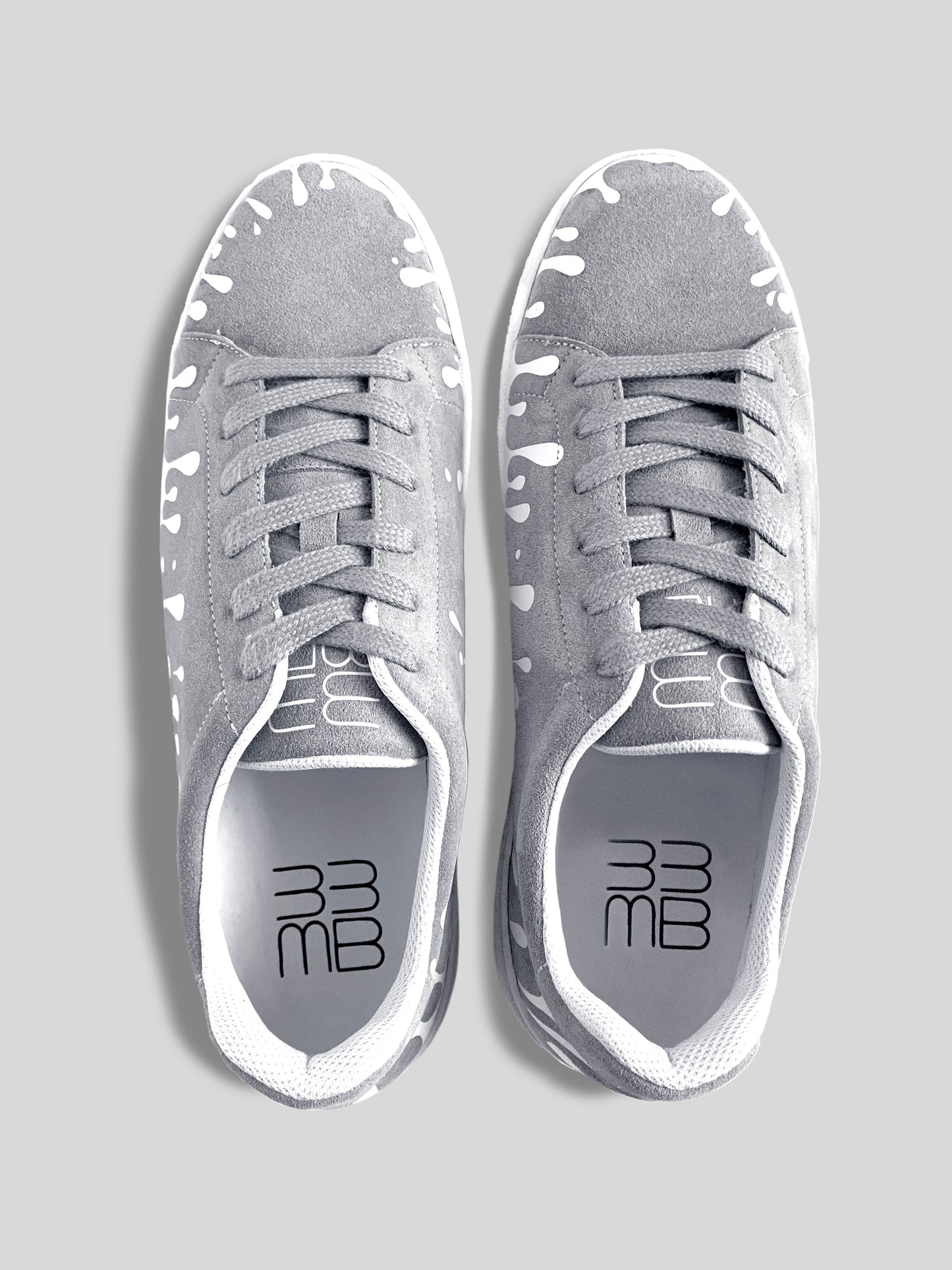 Top view of pair of grey suede low-top sneakers with exclusive printed white drops design