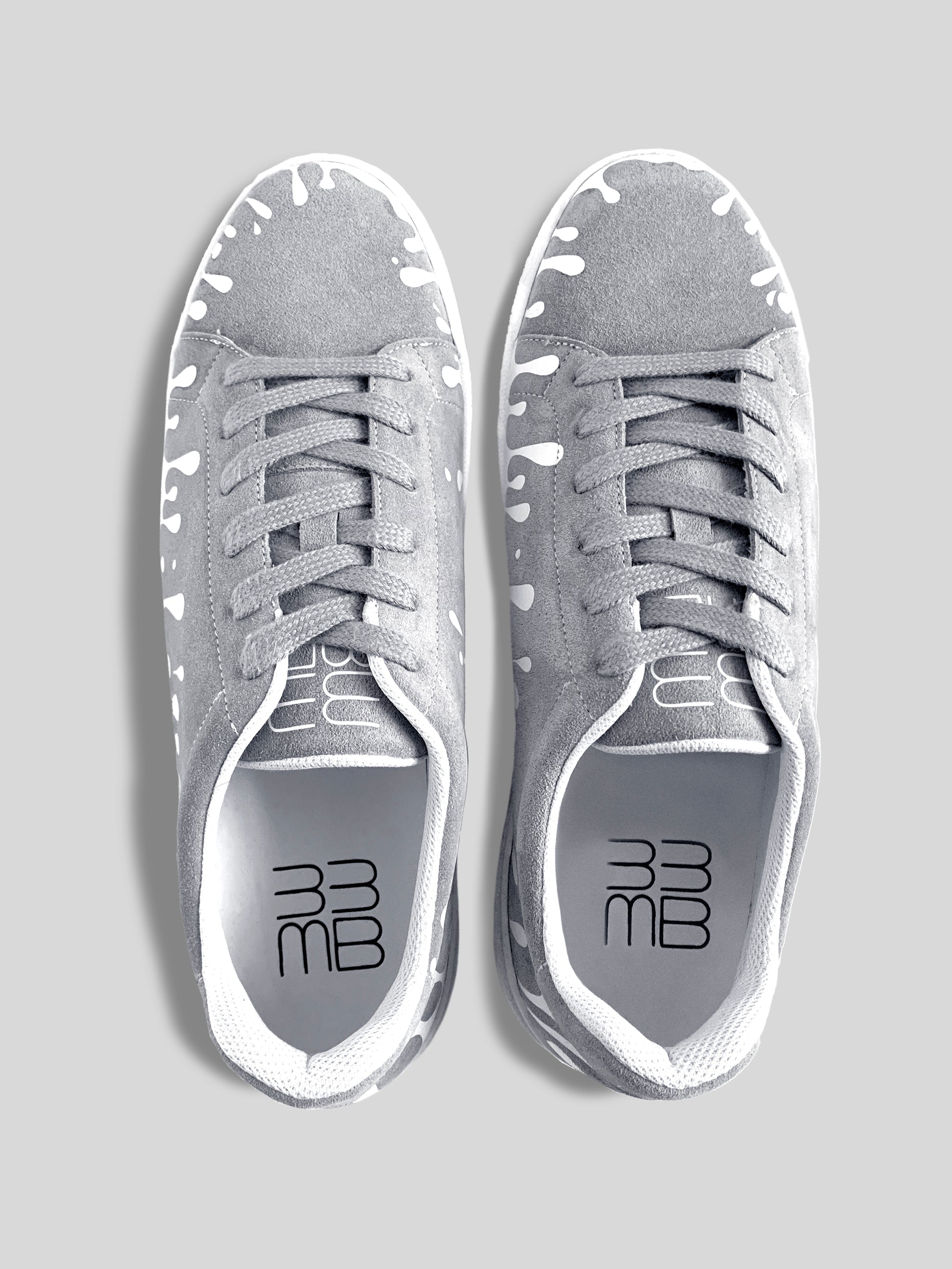 Top view of pair of grey suede low-top sneakers with exclusive printed white drops design