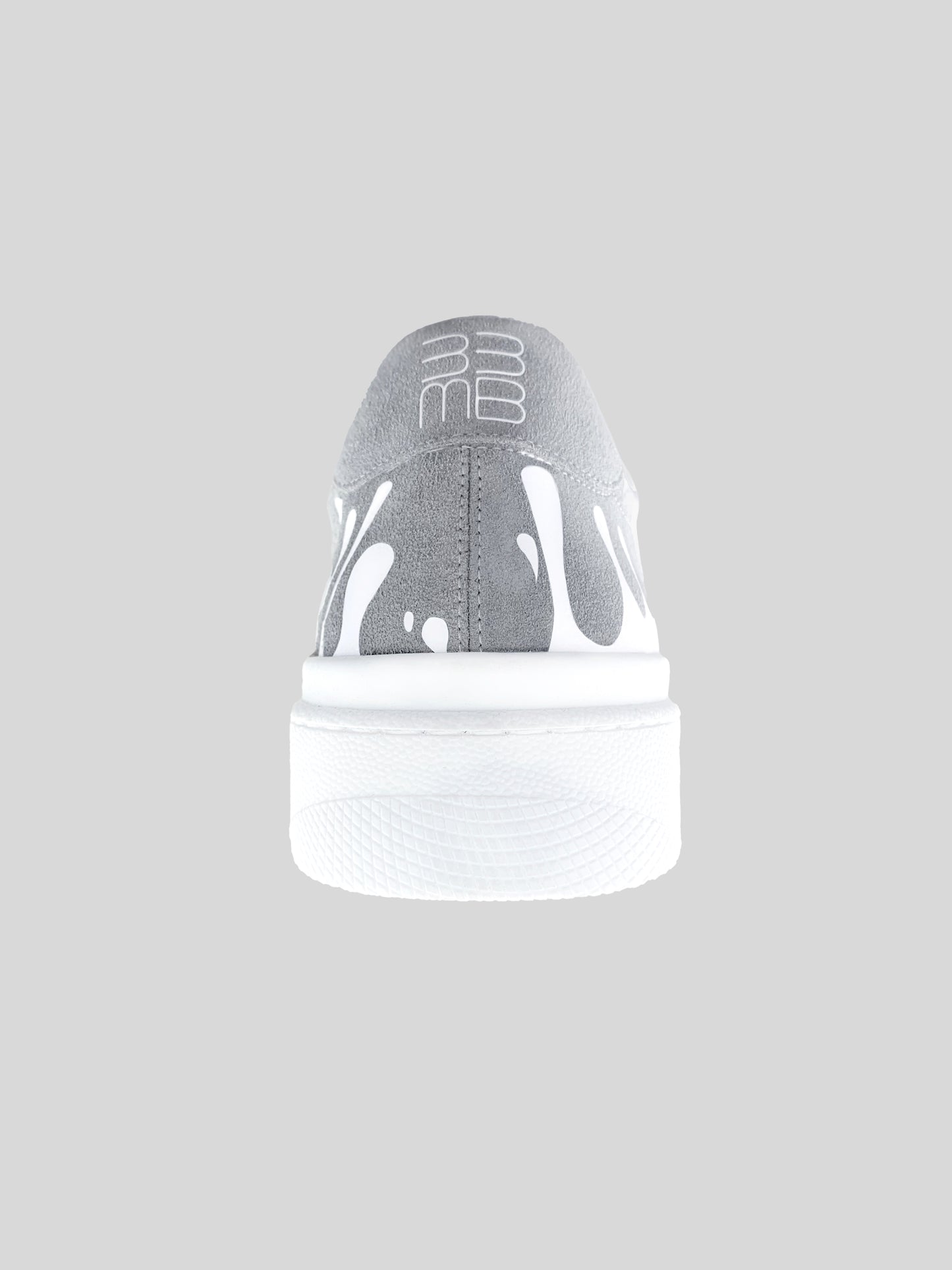 Back view of grey suede low-top sneaker with exclusive printed white drops design and white sole