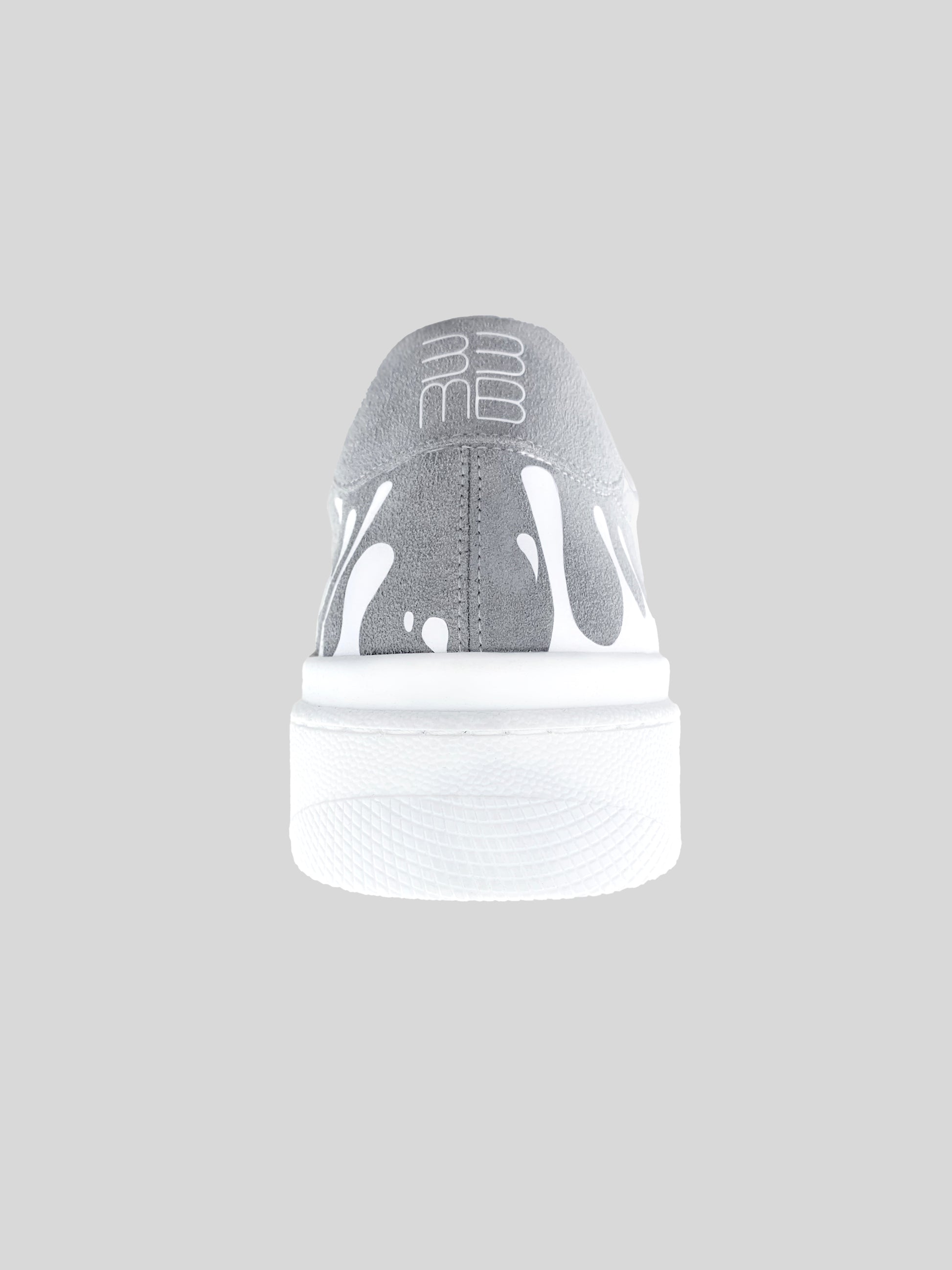 Back view of grey suede low-top sneaker with exclusive printed white drops design and white sole