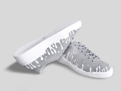 Upside down view of grey suede low-top sneakers with exclusive printed white drops design and white soles