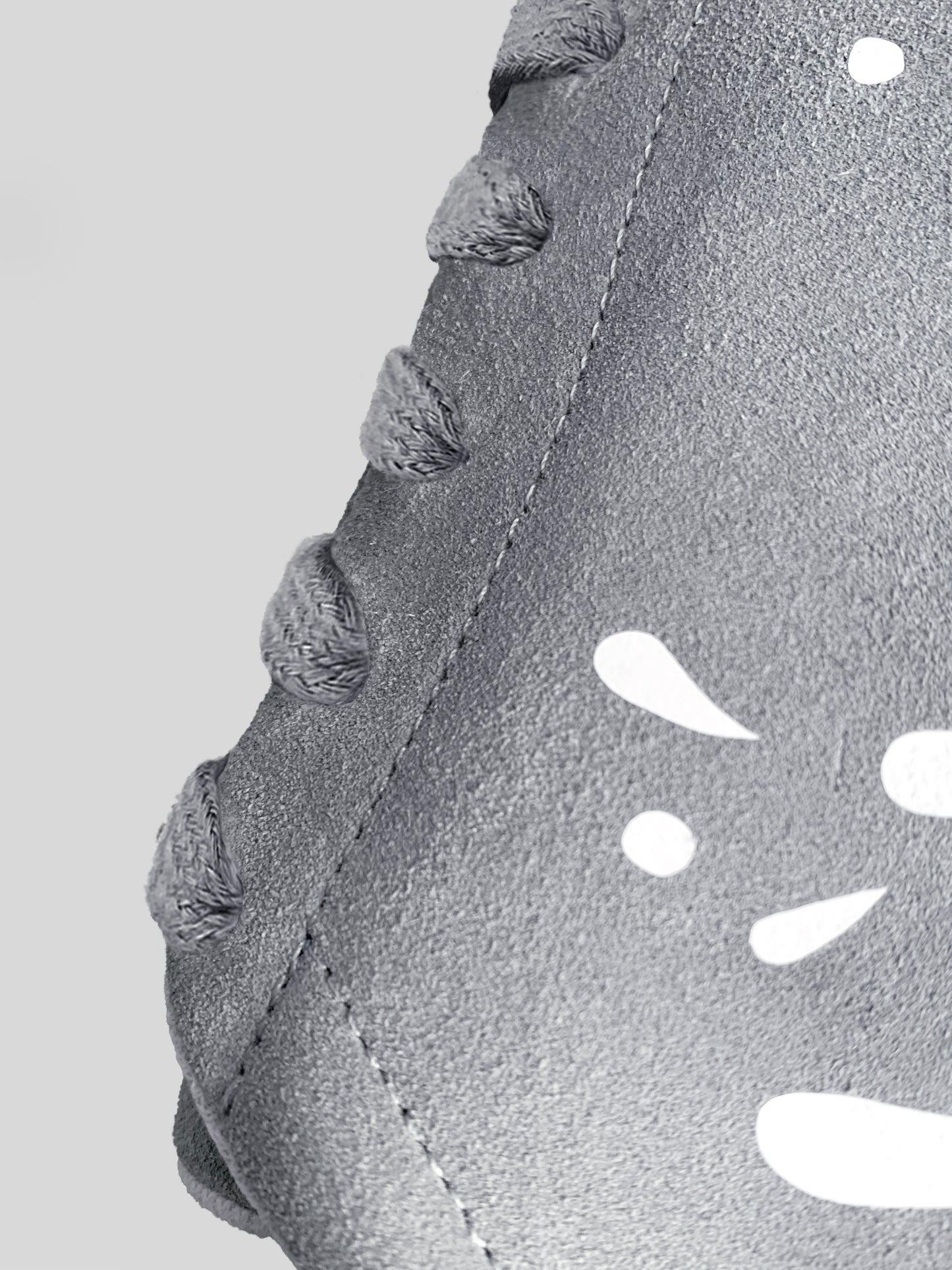 Side focus of grey suede low-top sneaker with exclusive printed white drops design and white sole