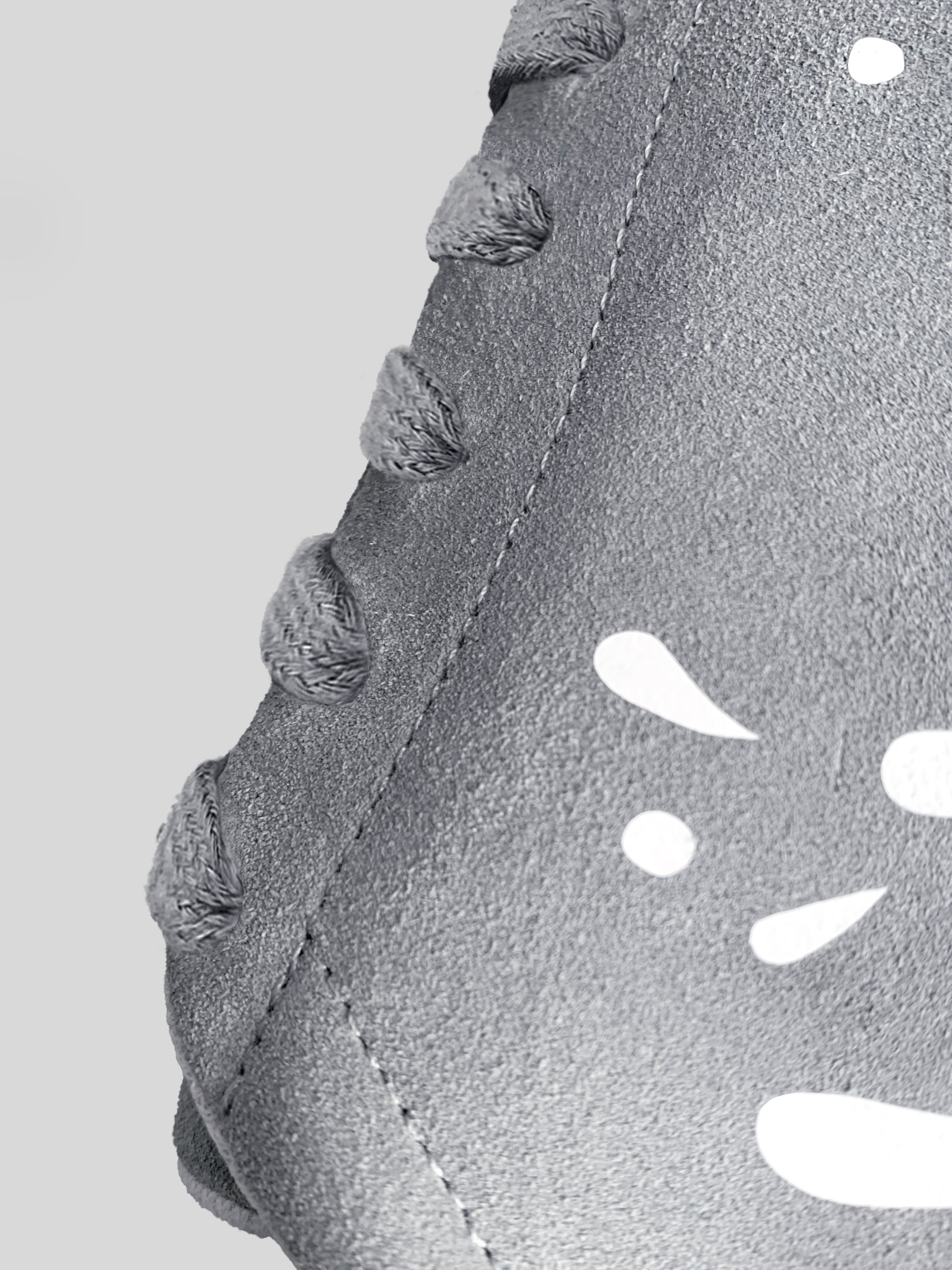 Side focus of grey suede low-top sneaker with exclusive printed white drops design and white sole